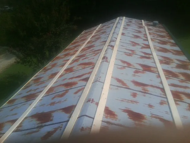 Rusted metal roof panels with new wood purlins before replacement — Storm Damage Roof Repair in Spring Arbor by Roofing Brothers