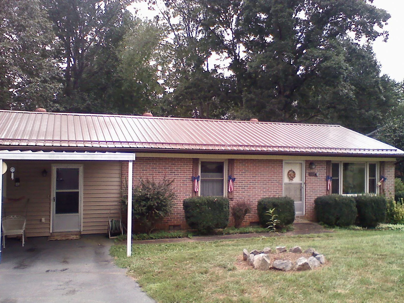 Bronze metal roof and carport on a brick ranch home — Roof Repair work by our crew in Spring Arbor